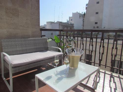 a table with two glasses of wine on a balcony at Room 56 - Le Dimore in Bari