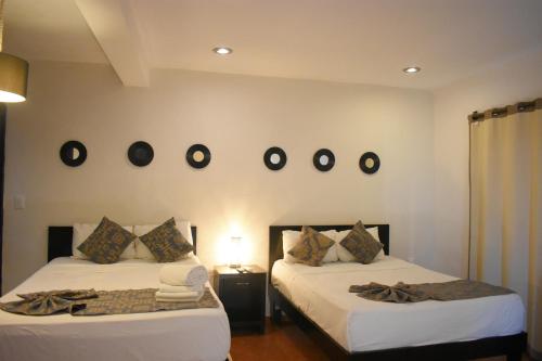 - 2 lits dans une chambre avec des miroirs sur le mur dans l'établissement Hotel Caracol Isla Mujeres, à Isla Mujeres