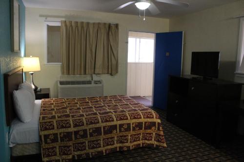 a hotel room with a bed and a television at American Inn Port O'Connor in Port O'Connor