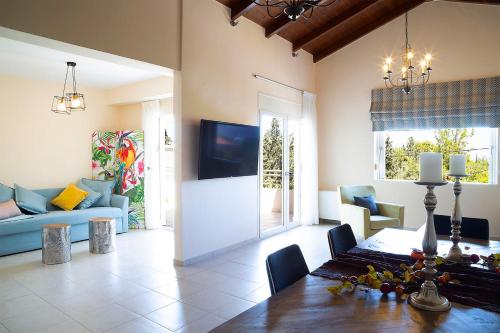 a living room with a dining room table and a couch at LOTOS - Luxury Apartments in Kounoupidhianá