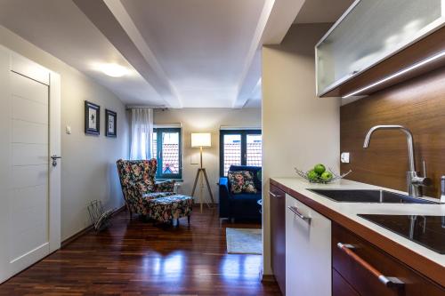 a kitchen with a sink and a living room at Apartamenty na Starówce / Old Town apartments in Toruń