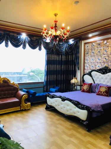 a bedroom with a bed and a chandelier and a window at Elisa Hotel in Ninh Binh