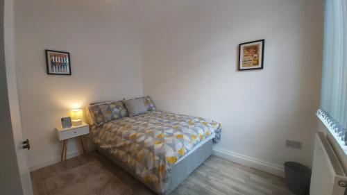 een kleine slaapkamer met een bed en een nachtkastje bij Parton Residence in Liverpool