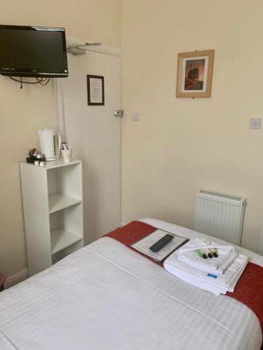 a bedroom with a bed with a tv on the wall at The Island & Fairfield in Douglas