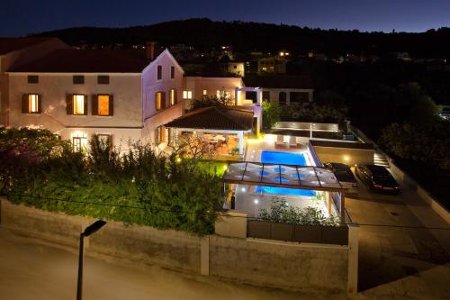 a view of a house at night with a pool at Apartments Guc in Preko