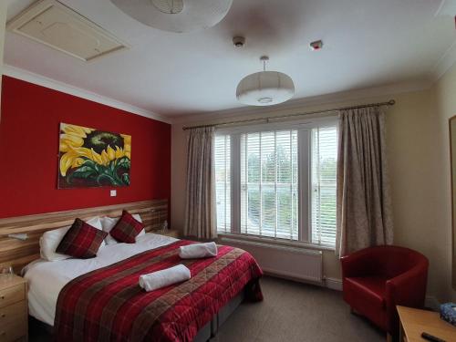 德比的住宿－花盆賓館，一间卧室设有一张床和红色的墙壁