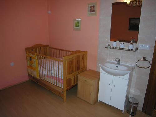 a bathroom with a crib and a sink at Villa Holiday in Karlovy Vary