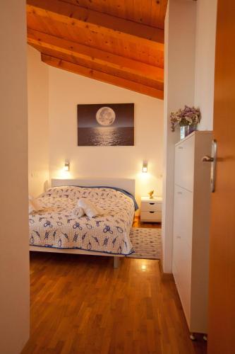 a bedroom with a bed and a wooden floor at Apartments Guc in Preko