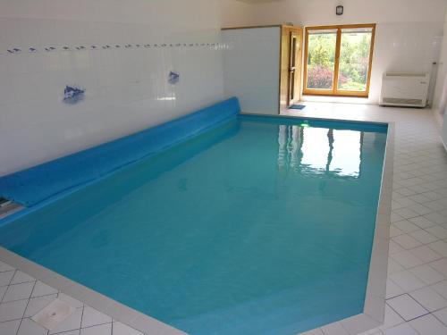 a large swimming pool in a white room with at Villa Holiday in Karlovy Vary