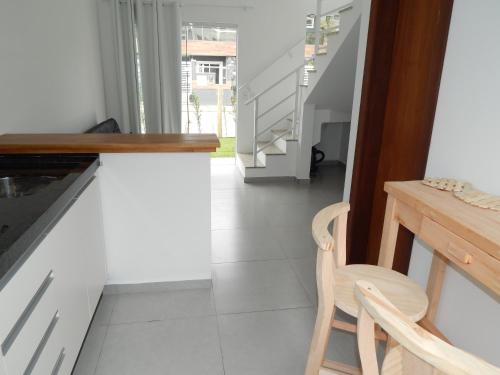 Zimmer mit einem Tisch, einem Stuhl und einer Treppe in der Unterkunft Residencial Farol das Conchas in Bombinhas