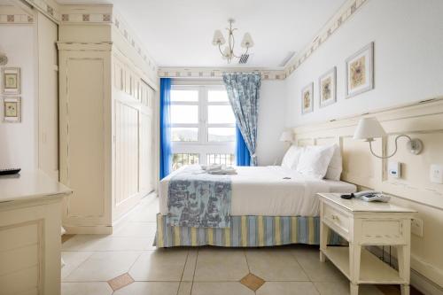 a bedroom with a large bed and a window at IL Campanário Villaggio Resort Suites - Jurerê Internacional in Florianópolis