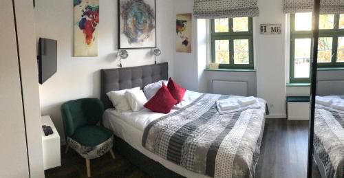 a bedroom with a bed and a green chair at GREENY in Wrocław