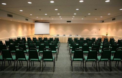 a lecture hall with green chairs and a whiteboard at Transamerica Executive Higienópolis in Sao Paulo