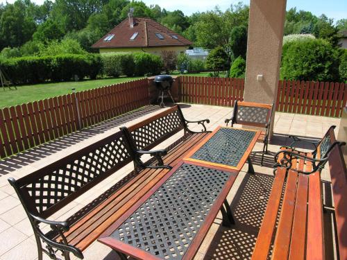 three benches sitting on a patio in a yard at Villa Holiday in Karlovy Vary