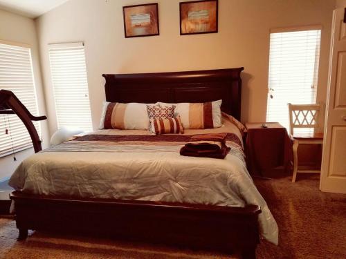 a bedroom with a large bed and two windows at Cozy and Conveniently located Pool Home with Free WiFi in Tampa
