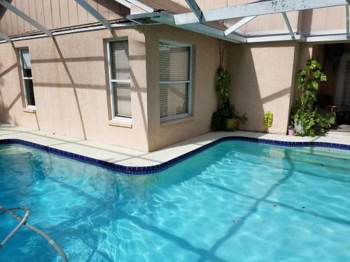 a large swimming pool in a building with a building at Cozy and Conveniently located Pool Home with Free WiFi in Tampa