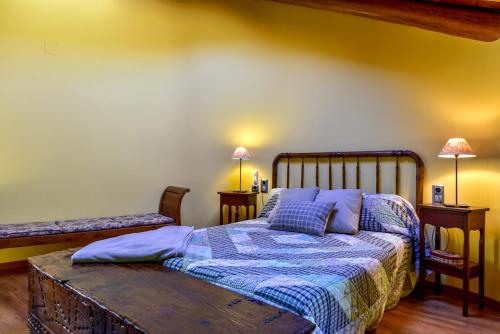 a bedroom with a bed and two tables and two lamps at Cal Gineró in Vall de Castellbò