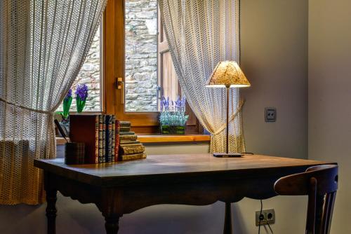 a table with a lamp on it in a room with a window at Cal Gineró in Vall de Castellbò