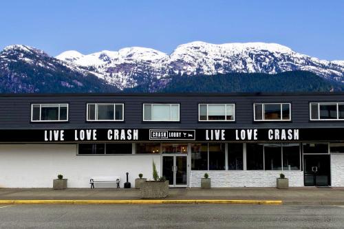 a black building with snow covered mountains in the background at Crash Hotel Squamish in Squamish