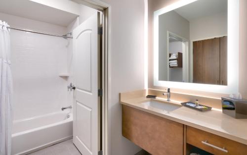 a bathroom with a sink and a shower and a mirror at Staybridge Suites - Lehi - Traverse Ridge Center by IHG in Lehi
