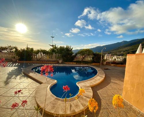 a large swimming pool with flowers in a courtyard at Casas Balcón del Mar in El Paso