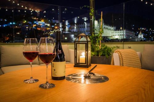 a table with two glasses of wine and a lantern at Antigua Trece Hotel Fusión in Guanajuato