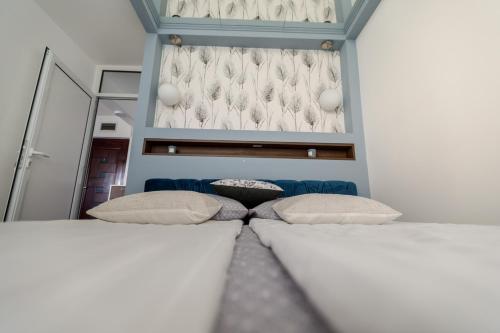 a room with two beds and a blue couch at Kristall Apartments 2 Panorama in Šabac
