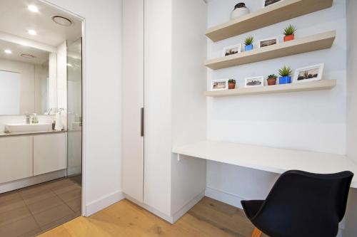 Adelaide的住宿－斯溫森維艾公寓，白色的浴室设有书桌和黑椅