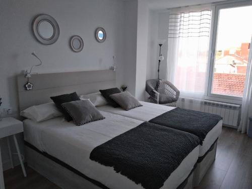 a bedroom with a large bed and a window at Morriña in Ourense