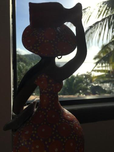 a statue of a woman in a dress in front of a window at Casas Coloniais in Morro de São Paulo