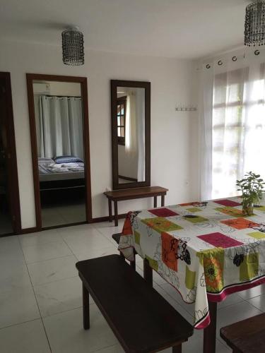 a bedroom with a bed and a table and a mirror at Casas Coloniais in Morro de São Paulo