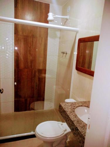 a bathroom with a shower and a toilet and a sink at Mata Virgem Hostel e Pousada in Abraão