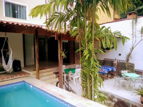 a villa with a swimming pool and a house at Mata Virgem Hostel e Pousada in Abraão