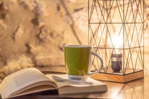 a book and a cup of green coffee on a table at La Casa Rosa in Terni
