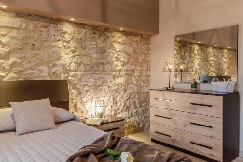 a bedroom with a bed and a stone wall at La Casa Rosa in Terni