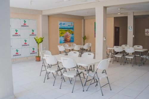a conference room with white tables and white chairs at Hotel America Pucallpa in Pucallpa