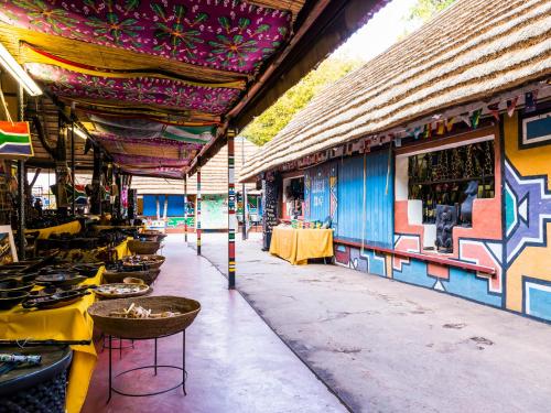 a restaurant with tables and chairs in front of a building at aha Lesedi African Lodge & Cultural Village in Pelindaba