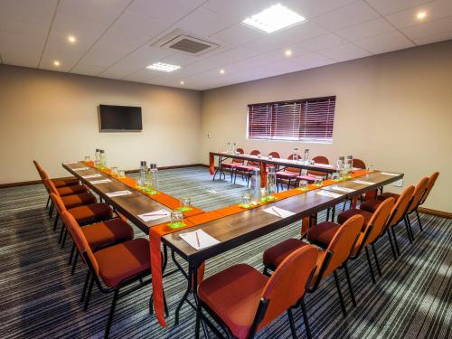 a conference room with a long table and chairs at aha Lesedi African Lodge & Cultural Village in Pelindaba