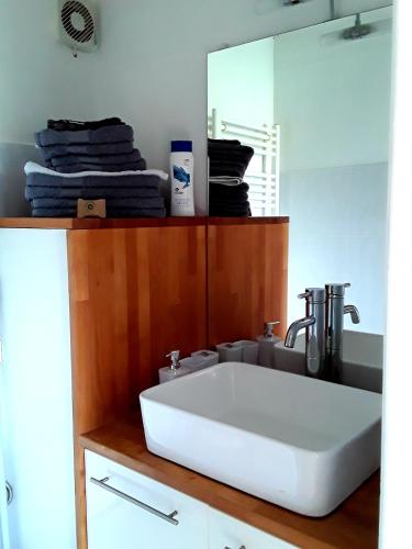 une salle de bain avec un lavabo blanc et un miroir dans l'établissement Ty Biz, à Saint-Jean-Trolimon