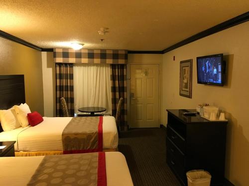 a hotel room with two beds and a flat screen tv at Ramada by Wyndham Ontario Airport & Convention Center in Ontario