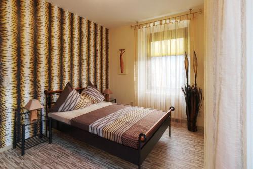 Schlafzimmer mit einem Bett und einem Fenster in der Unterkunft Mosella Ferienwohnungen in Bernkastel-Kues