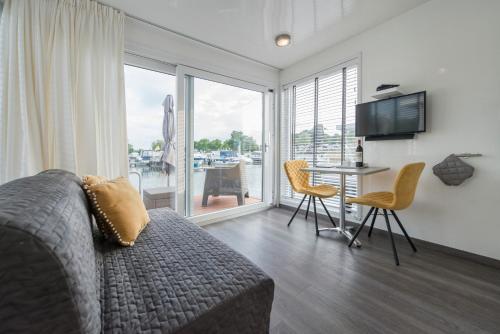 a living room with a couch and a table with chairs at Boatlodge Antigua in Maastricht
