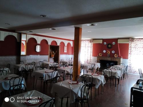 comedor con mesas y sillas y chimenea en Hostal Restaurante El Parador, en Alcaracejos