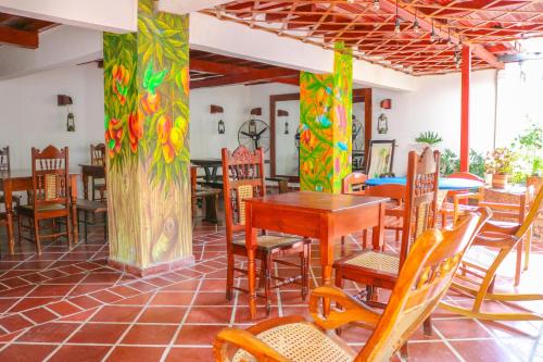 un restaurante con mesas y sillas en una habitación en Hotel Jardines Evans By GEH Suites en Mompox