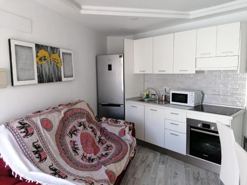 a kitchen with a couch and a refrigerator at wonderful white appartament in las Tortugas in Arona