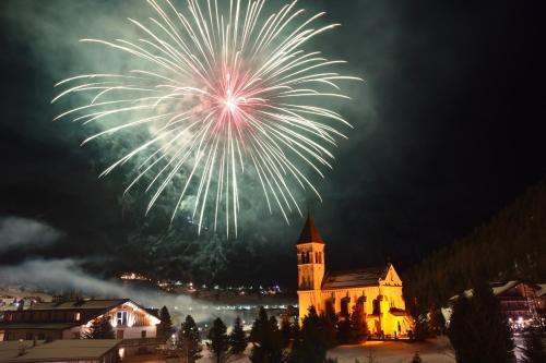 a fireworks display over a building with a church at Bed & Breakfast Hostel Nives in Solda