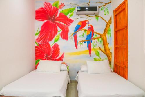 a room with two beds with a mural of flowers at Hotel Jardines Evans By GEH Suites in Mompos