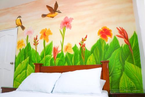 a bedroom with a mural of flowers and birds at Hotel Jardines Evans By GEH Suites in Mompos