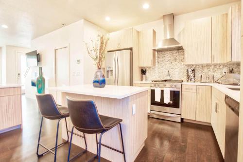a kitchen with a island with three chairs in it at Beautiful 3 Bedroom Townhouse in Old Town North, Brewery District in Fort Collins