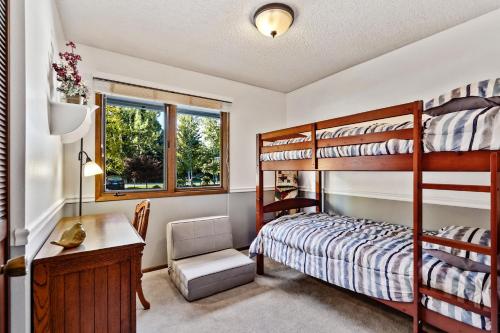 a bedroom with two bunk beds and a desk and a window at Sandpoint Paradise in Sandpoint